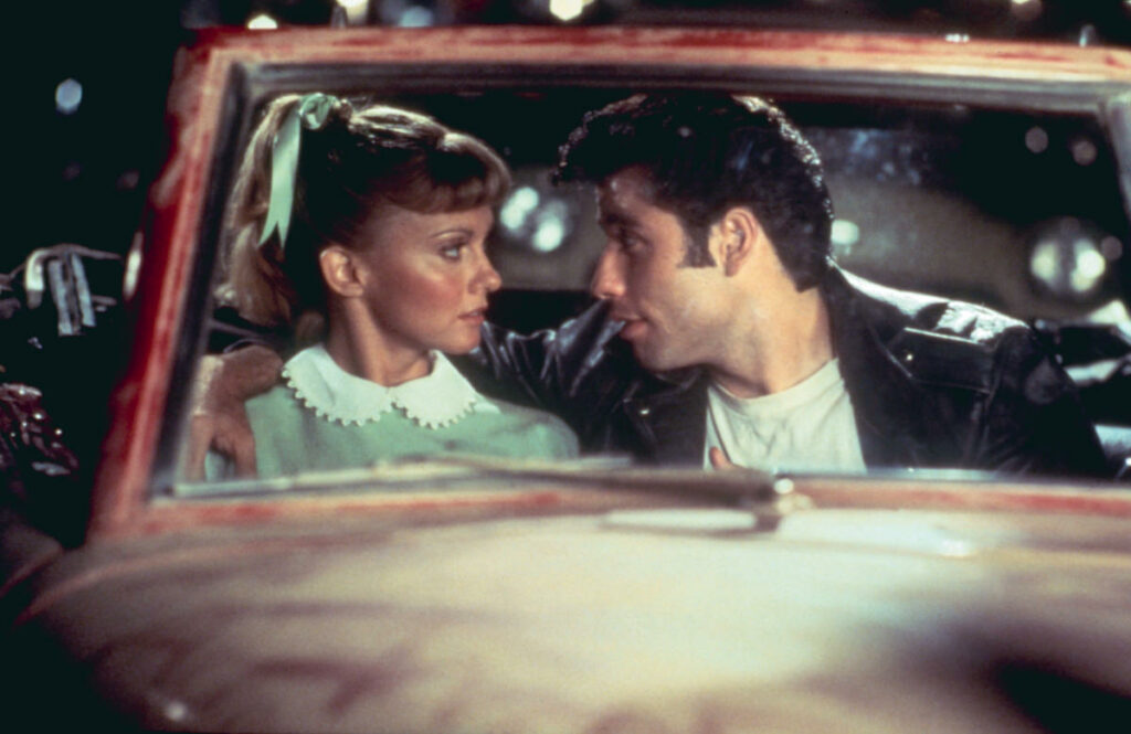 Sandy (Olivia Newton-John) et Danny (John Travolta) dans le film Grease, scène du ciné-parc (source : Grease)